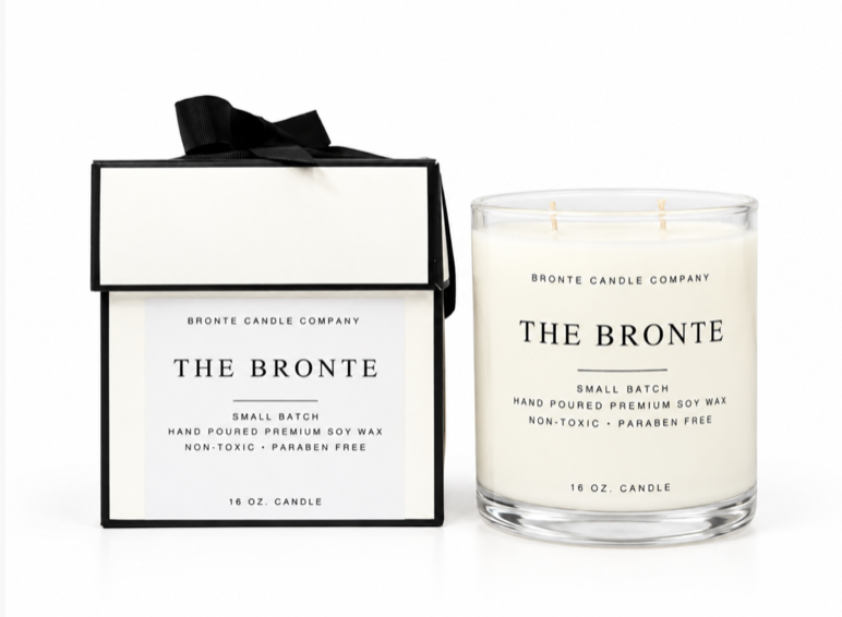 The Bronte soy candle alongside its cream gift box, finished with a black ribbon